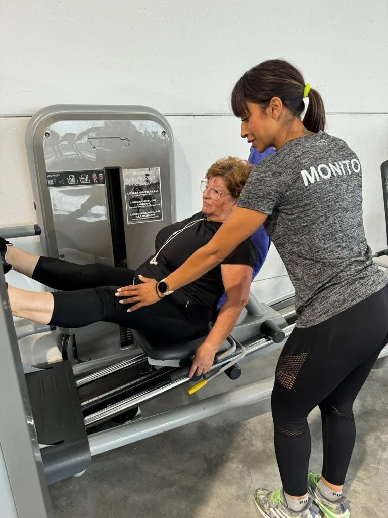 A Fit Express 24 coach helping a member use the equipment