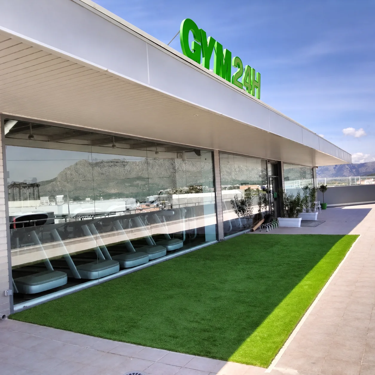 Fit Express 24 terrace with GYM24 sign and mountain views
